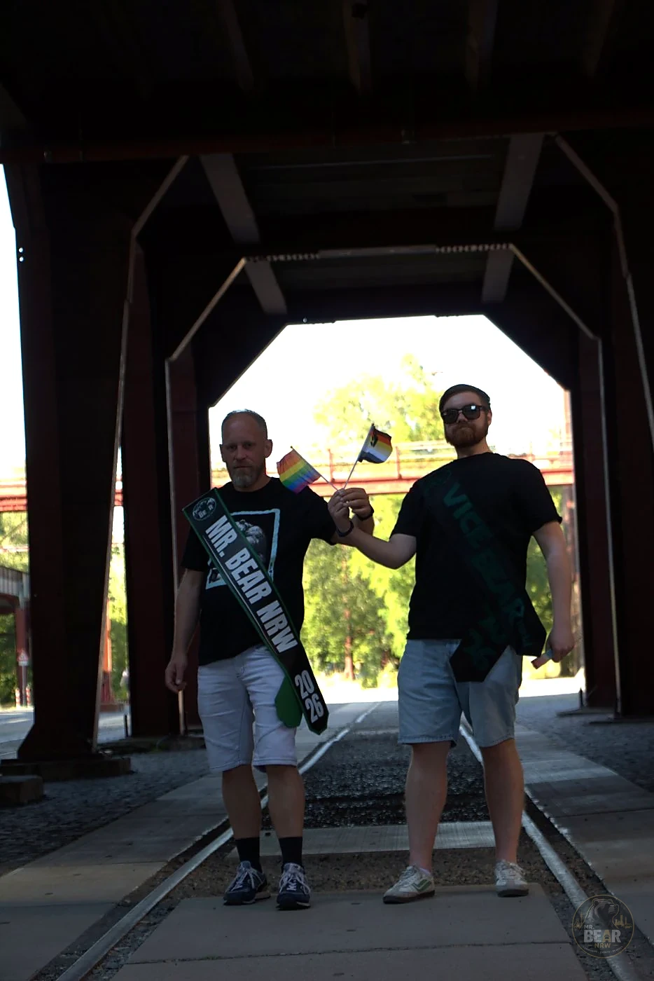 Christoph und Joshua mit Schärpen und kleinen Pride-Flaggen